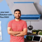 A young Indian man standing in the kitchen with MyHomePlus DSG disinfectant solution spray in the frame.
