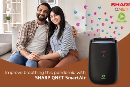 A young couple sitting on the couch with SHARP QNET SmartAir air purifier in the frame