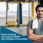 A young and healthy man standing with arms crossed in his home with Nutriplus ImmunHealth by QNET in the frame