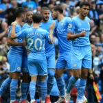 Manchester City players celebrating in the Etihad Stadium after a great start in the Premier League.