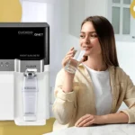 A young lady drinking water from Cuckoo water purifier