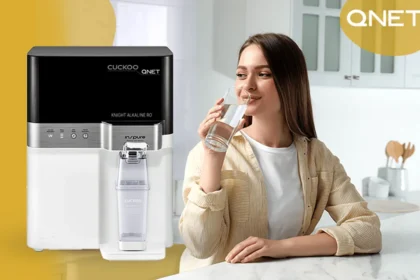 A young lady drinking water from Cuckoo water purifier