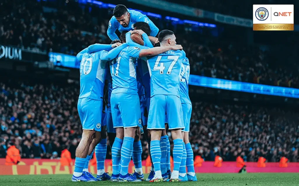 Manchester City players celebrating after scoring a crucial goal in the Premier League