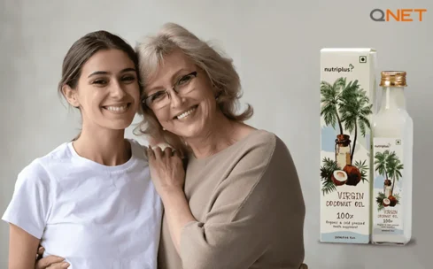 Mother-standing-with-her-daughter-at-home-with-Nutriplus-Virgin-Coconut-Oil-VCO-by-QNET-India-in-the-frame
