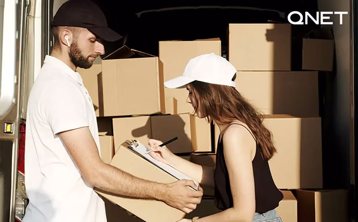 QNET staff moving boxes for charity