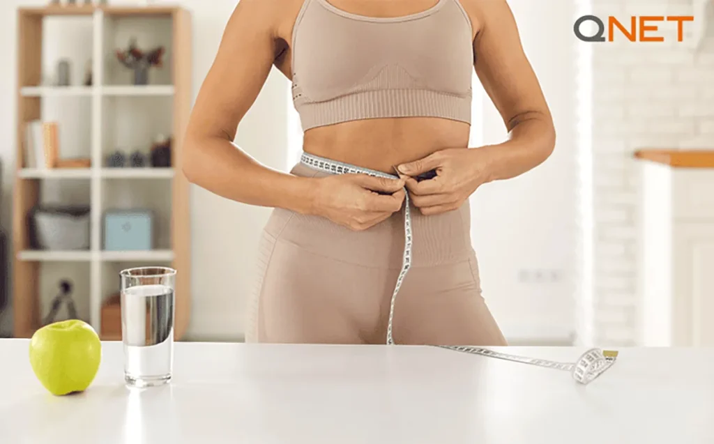 A measuring tape around the waist of a mid-age woman