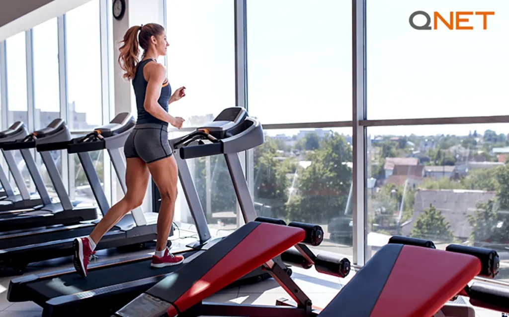 A young female athlete training alone on the treadmill