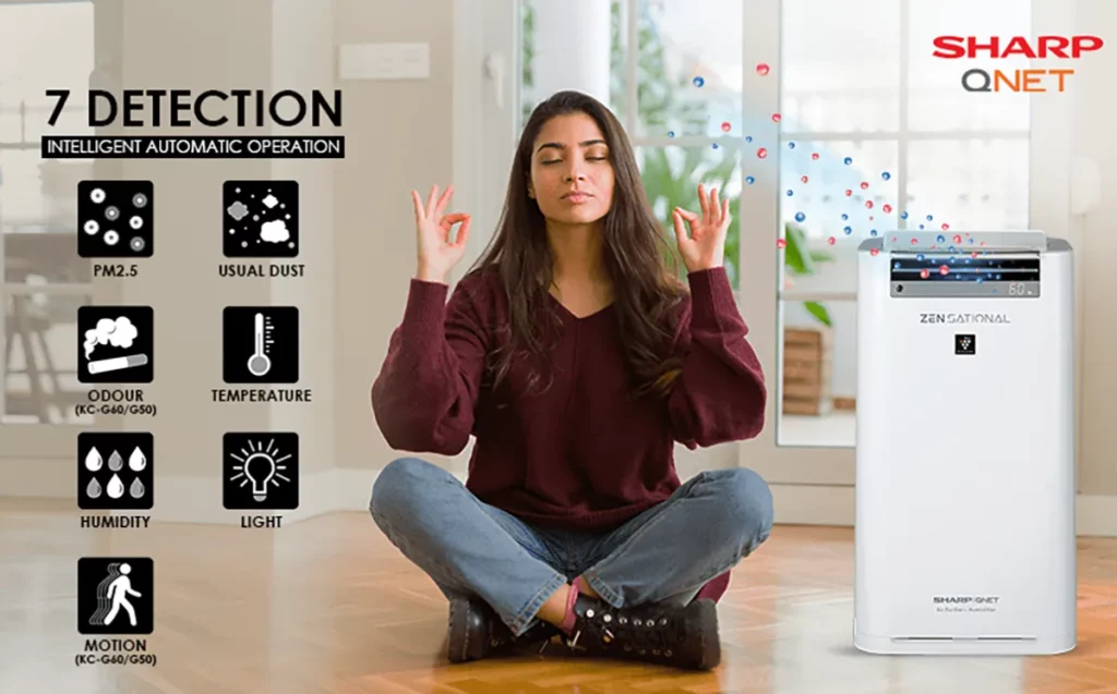 Young Indian woman sitting on the floor breathing fresh with SHARP QNET ZENsational air purifier in the frame