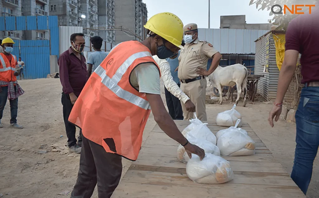 A construction worker collecting meals provided by Parinaama Development Foundation with the support of QNET’s CSR arm RYTHM Foundation
