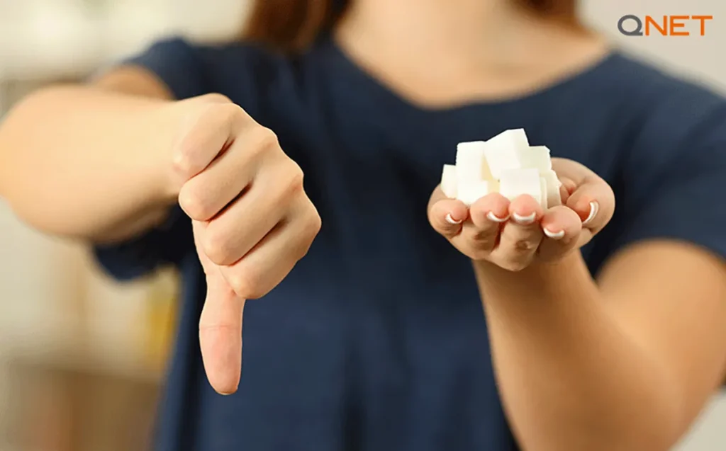A health-conscious woman beating sugar addiction by saying no to sugar with sugar cubes in her hand