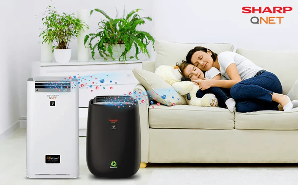 A mother fallen asleep with her daughter on the couch with SHARP QNET SmartAir and ZENsational air purifier