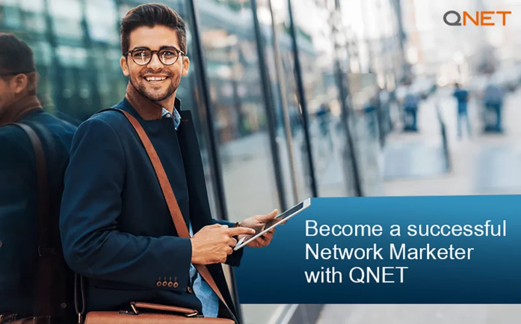 A successful QNET distributor smiling while standing outdoors with a tablet