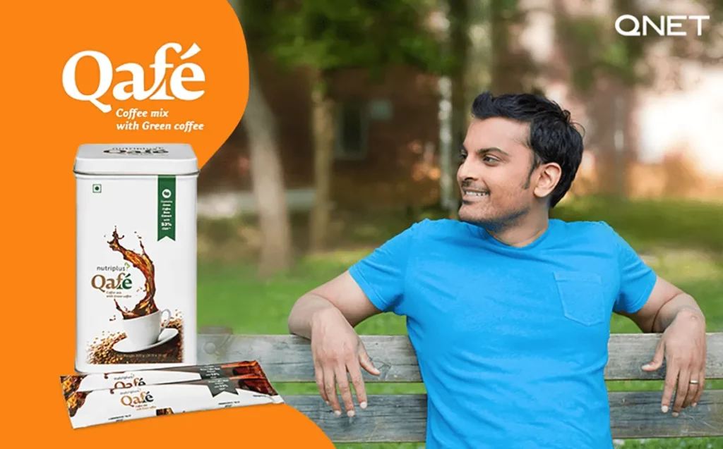 A young Indian man sitting on a park bench with Nutriplus Qafé in the frame