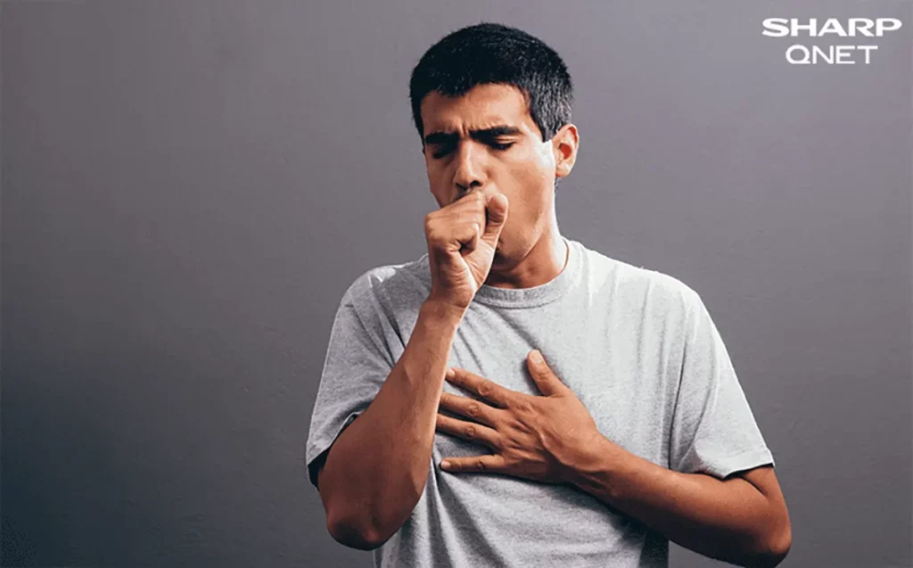 A young man coughing due to a lack of humidity control at home causing indoor air pollution