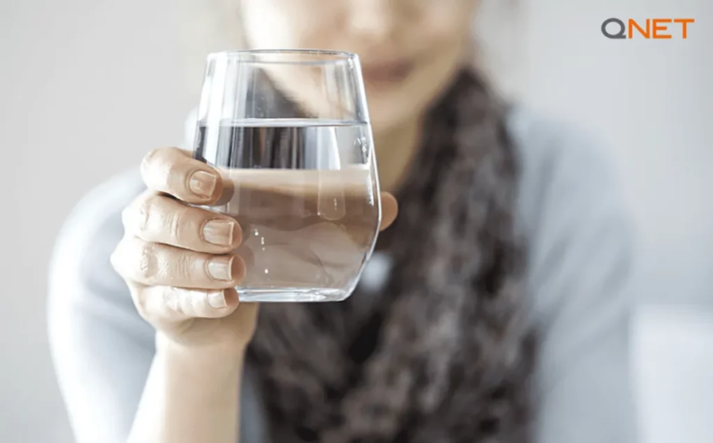 A young woman drinking water from a clean glass