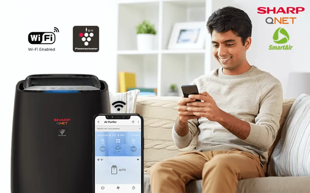 An Indian man enabling features of the SmartAir air purifier with the SHARP Air app on the phone