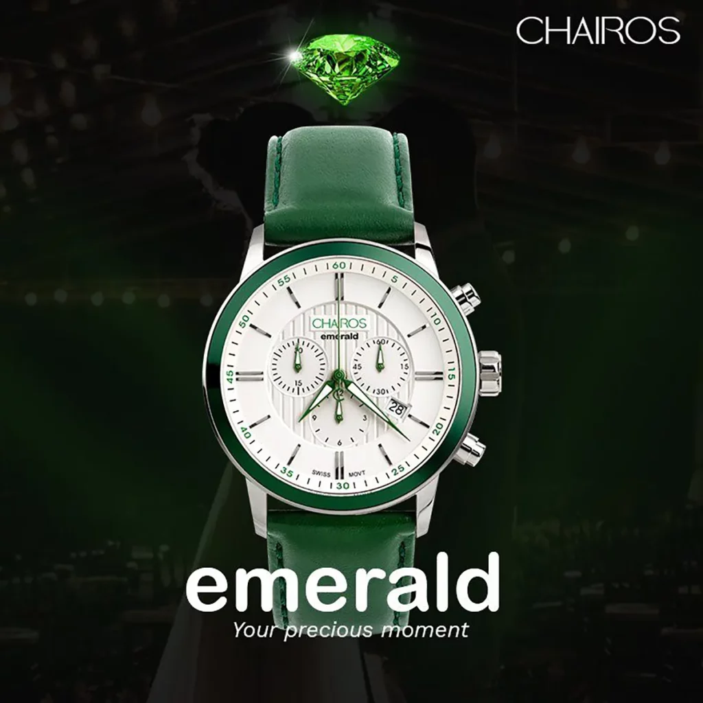 CHAIROS Emerald watch with an emerald stone above and a couple in the background.