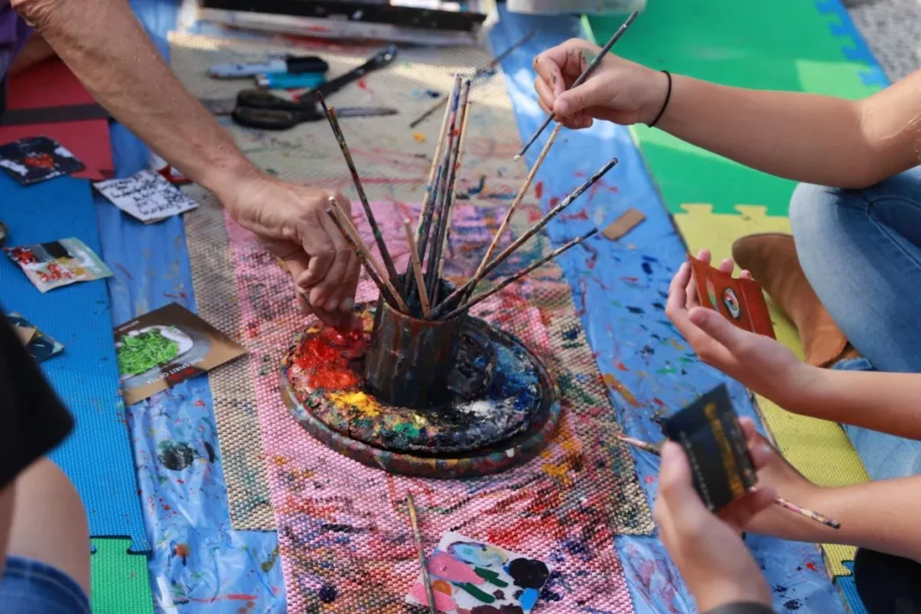 Friendship Day 2019: Hands of people with paint brushes at a workshop