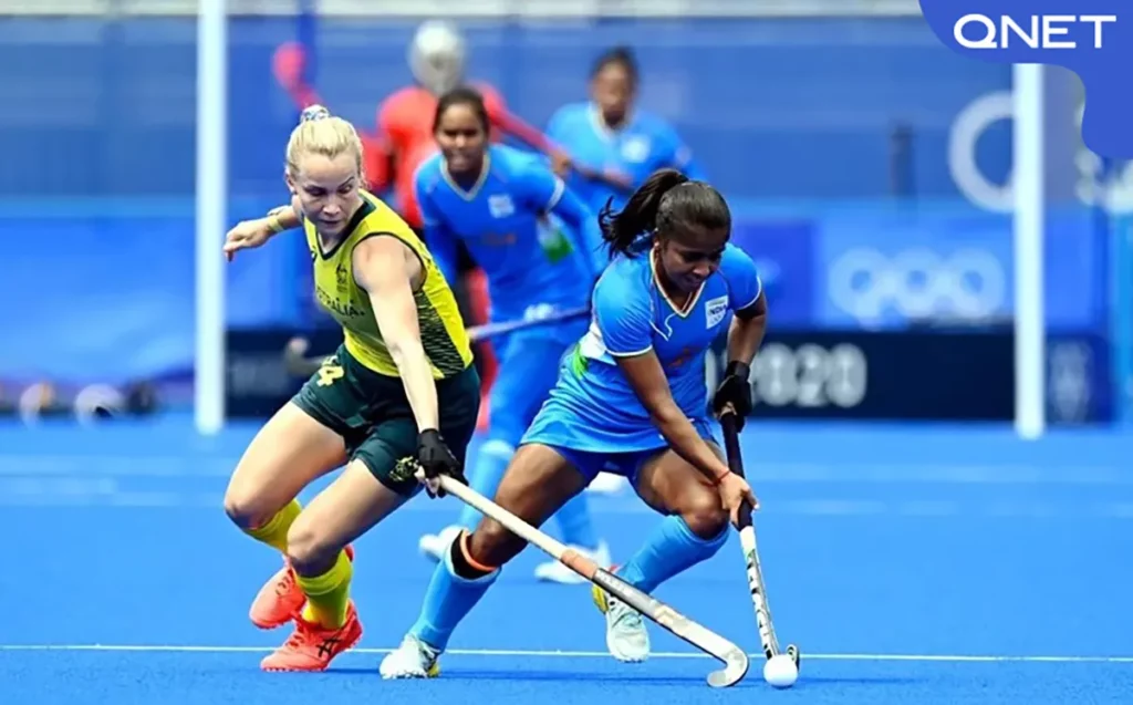 Indian women’s hockey team player dribbling the ball in the centre of the field with an Australian player attempting to tackle during the Olympics 2020