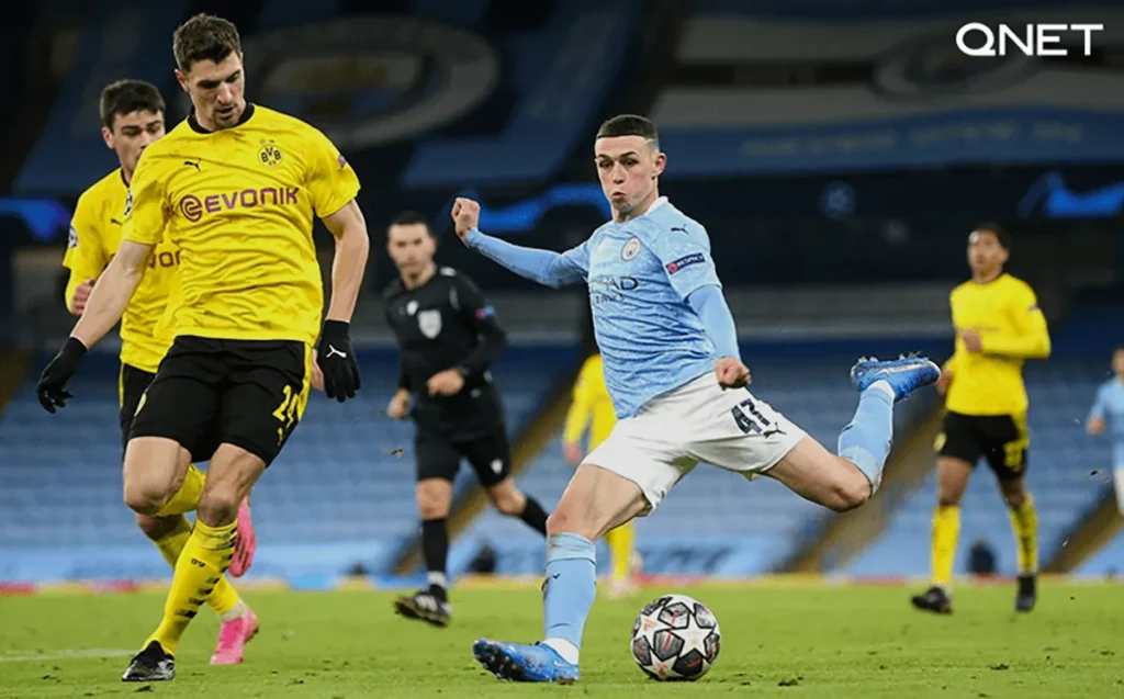 Phil Foden shooting in a match against Borussia Dortmund in the Champions League