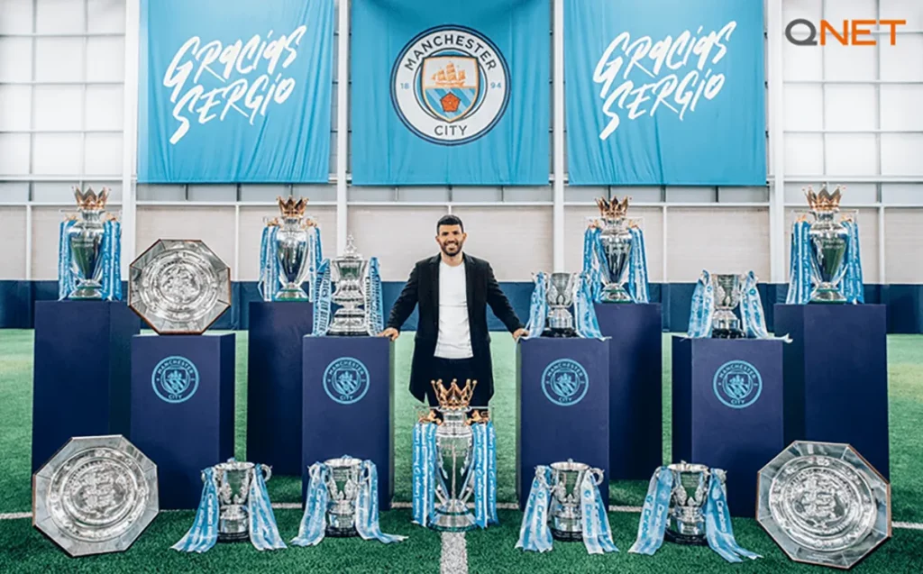 Sergio Aguero posing with all the trophies won at Manchester City