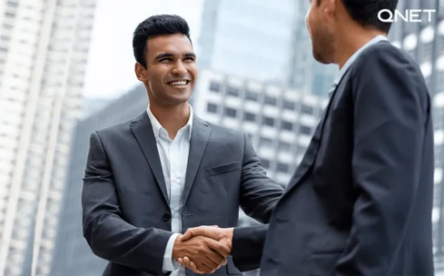 two men shaking hands outdoors