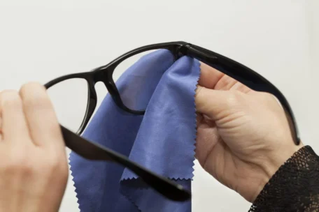 man cleaning glasses with a towel