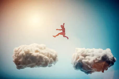 person jumping across two clouds