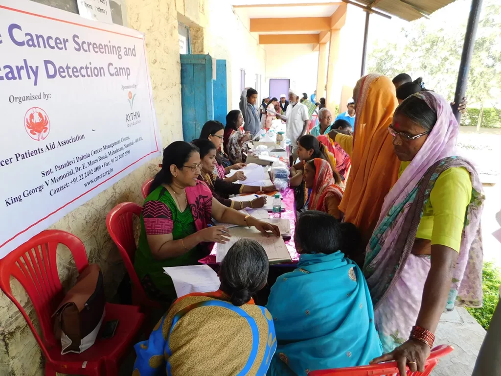 RYTHM Foundation: Locals gathered around registration desk at Cancer screening and early detection camp