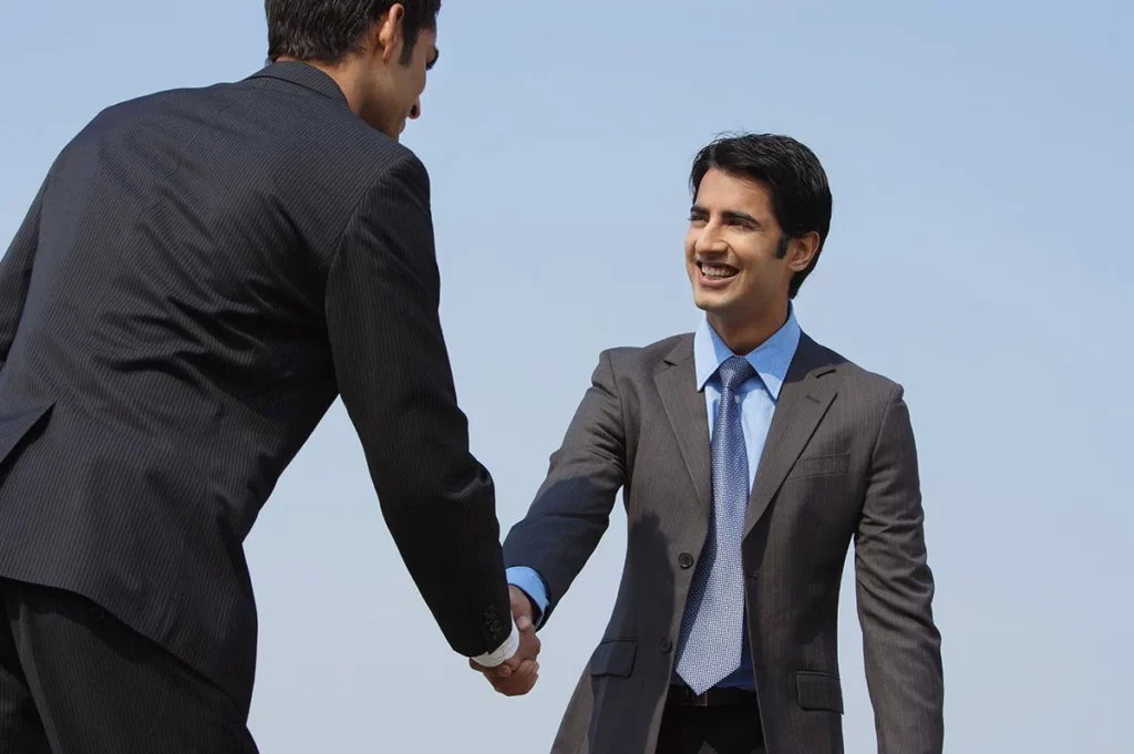 networking skills - man shaking hands in confidence to make an impression