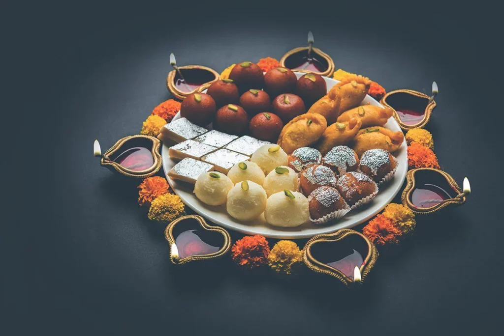 Spread of sweets with diyas for the festival season