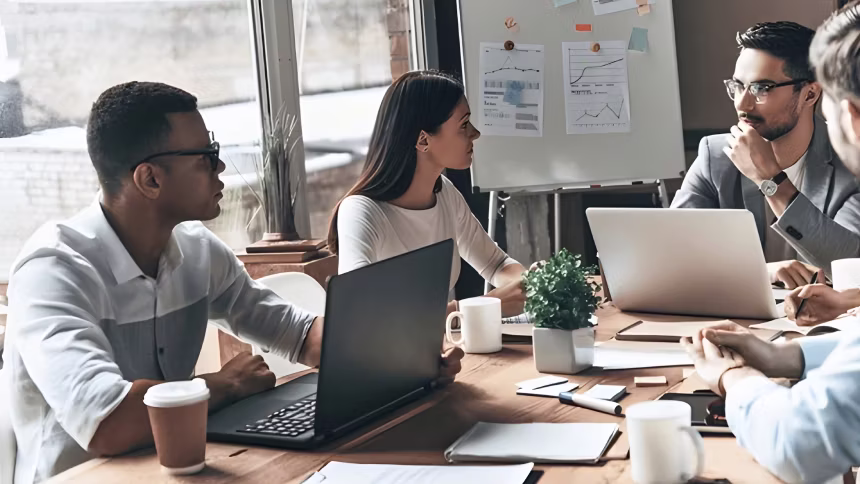 group of people in a meeting with laptops